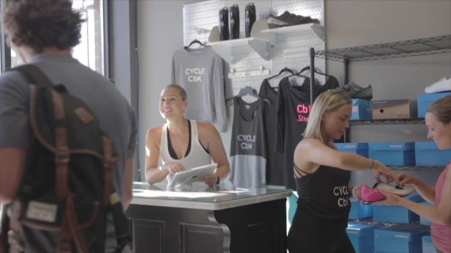 The CbK front desk in daylight, with CYCLE CbK shirts on the wall